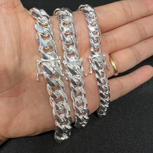 May include: Three silver curb chain bracelets of varying widths.