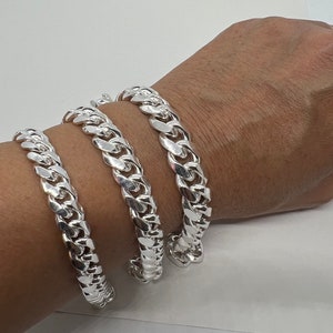 May include: Three silver curb chain bracelets of different widths.