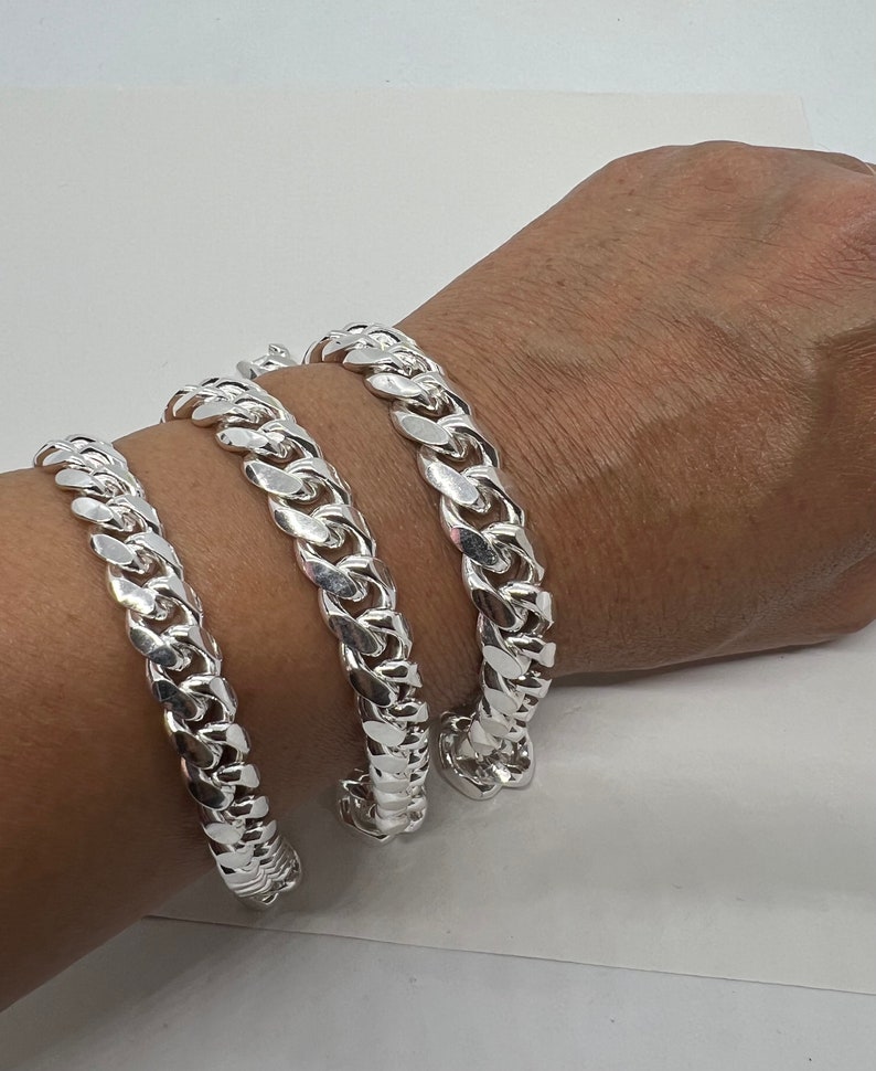 May include: Three silver curb chain bracelets of different widths.