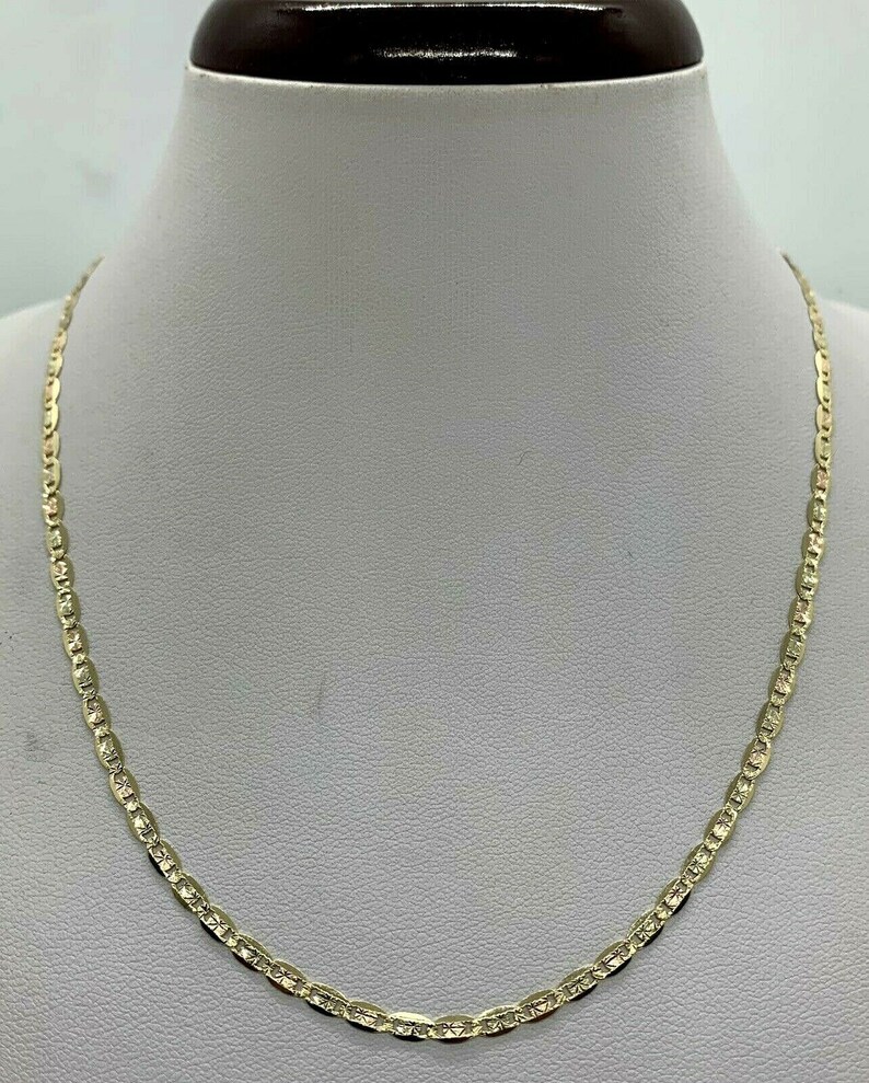 May include: A gold chain necklace with a mariner link design. The chain is on a white mannequin bust.