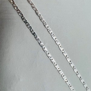 Puede incluir: Dos cadenas de plata con un patr&oacute;n de estrella en cada eslab&oacute;n.