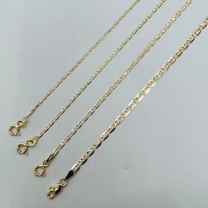 May include: Four gold-coloured necklaces with varying chain styles are shown against a light background. Each chain has a clasp at the end. The chains differ in thickness and design, showcasing a range of jewellery options.