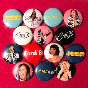 May include: A collection of 11 round button pins featuring various images of Cardi B, including a close-up of her face, a photo of her performing, and a graphic with the text "Cardi B".  There are also buttons with the text "Privacy" and "Rodak Sadie Cardi B But Bick".
