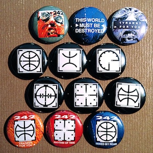 May include: A collection of 11 round black and white buttons with various symbols and text. The buttons feature a basketball, a clock, a cross, a symbol with a circle and a line through it, and the text "242", "Tragedy for You", "Rhythm of Time", "Mixed by Fear", "This World Must Be Destroyed", and "Tyranny for You".