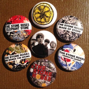 Könnte beinhalten: Ein Set mit neun runden Anstecknadeln mit verschiedenen Designs und Texten rund um die Band The Stone Roses. Die Nadeln sind bunt und zeigen eine Vielzahl von grafischen Designs, darunter eine Zitrone, ein Bandfoto und abstrakte Muster. Der Text auf den Nadeln umfasst Songtitel und Albumnamen.