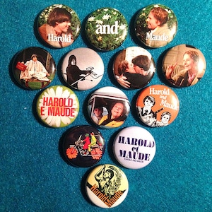 Könnte beinhalten: Eine Sammlung von zehn runden Anstecknadeln mit verschiedenen Bildern und Texten zum Film "Harold und Maude". Die Nadeln zeigen Bilder der Hauptfiguren Harold und Maude sowie Szenen aus dem Film. Der Text auf den Nadeln lautet "Harold und Maude", "Harold", "Maude" und "and".