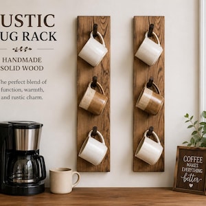 Może przedstawiać: Dwie pionowe deski z litego drewna zamontowane na ścianie, każda z trzema ciemnymi haczykami, na kt&oacute;rych wiszą ceramiczne kubki. Tekst głosi: RUSTIC MUG RACK, HANDMADE SOLID WOOD, The perfect blend of function, warmth, and rustic charm. COFFEE MAKES EVERYTHING better.