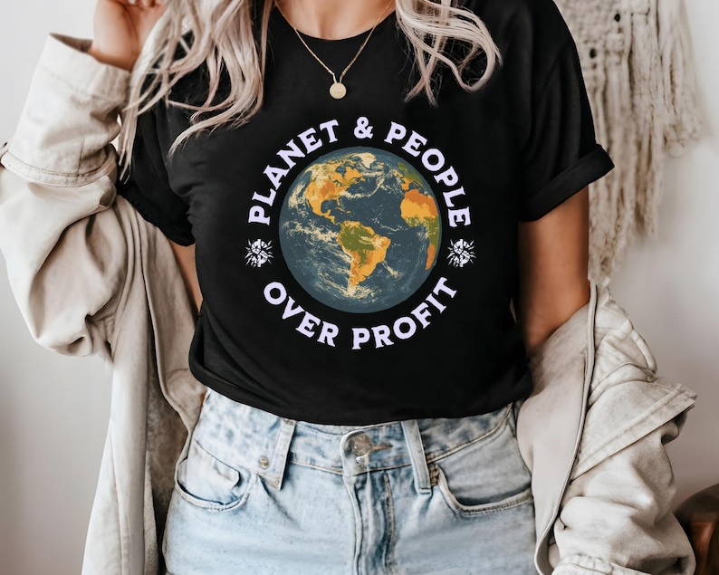 May include: A black t-shirt with a graphic of a blue and green earth with the text 'Planet & People Over Profit' in purple letters.