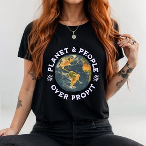 May include: Black t-shirt featuring a graphic of a blue and yellow globe with the text "Planet & People Over Profit" in white.