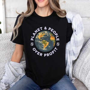 May include: A black t-shirt featuring a graphic of a blue and green earth with the text "Planet & People Over Profit" in white.