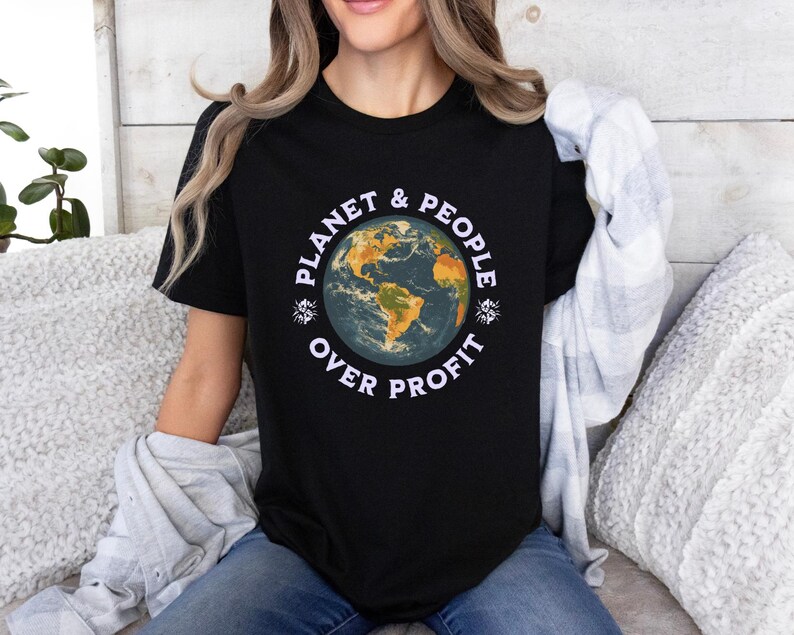May include: A black t-shirt featuring a graphic of a blue and green earth with the text "Planet & People Over Profit" in white.
