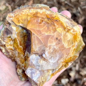 May include: A large, rough, natural piece of yellow and white opal with a translucent, crystalline texture.