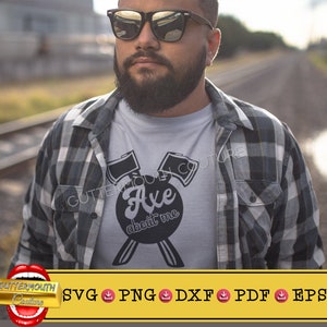 May include: A light gray t-shirt with the text "Axe about me" in a black oval, with two axes above and two axe handles below. The shirt is worn under a black and white plaid shirt.