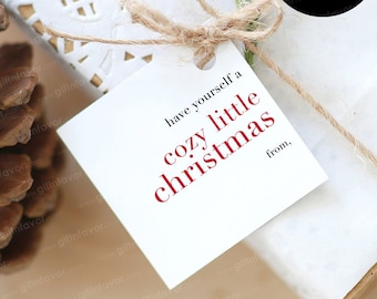 Könnte beinhalten: Weißer Geschenkanhänger mit dem Text "have yourself a cozy little christmas" in roten Buchstaben und "from," in schwarzen Buchstaben. Der Anhänger ist mit einer Schnur gebunden und hat eine Größe von 2,5 Zoll.