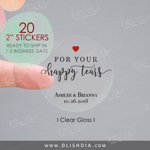 May include: Clear gloss stickers with the text "For your happy tears" in elegant script, a red heart, and the names Ashlee & Brianna with a date. The stickers are 5.08 cm in diameter.