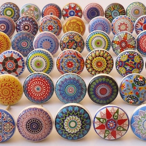 May include: Assortment of colourful ceramic knobs with intricate mandala designs. The knobs are round and have a white base with various colours and patterns.