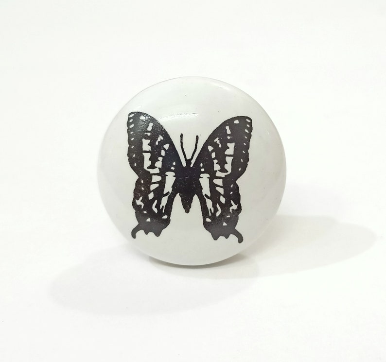 May include: White ceramic knob with a black butterfly design.