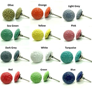 May include: A collection of twelve round ceramic cabinet knobs, each featuring an embossed floral pattern. The knobs are displayed in various colors including olive, orange, light grey, sea green, yellow, pink, dark grey, white, turquoise, red, green, and blue, each with a silver-toned metal bolt.