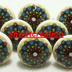 May include: Nine round ceramic knobs with a yellow background and a colourful mandala design. The mandala features a black centre with concentric circles of red, blue, green, and yellow dots.