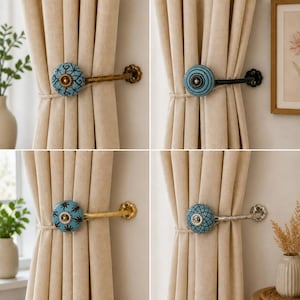 May include: Four curtain tiebacks featuring round ceramic knobs with blue and black patterns. Each knob is attached to a metal arm in gold, black, or silver finishes, secured to the wall with a floral-shaped base, holding beige curtains.