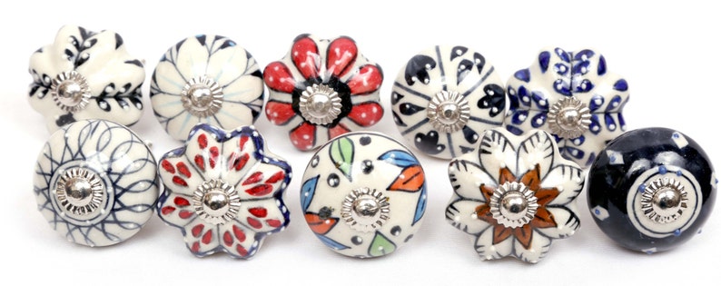 Puede incluir: Conjunto de diez pomos de armario de cer&aacute;mica con varios patrones florales y geom&eacute;tricos en azul, blanco, rojo y negro.