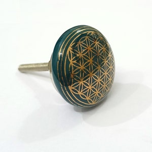 May include: A green ceramic cabinet knob with a gold flower of life design.