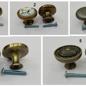 Pu&ograve; includere: Cinque stili diversi di pomelli per armadi in ottone antico con viti abbinate. I pomelli presentano vari disegni, tra cui un'esplosione di sole, un motivo floreale, una superficie strutturata e un motivo geometrico.