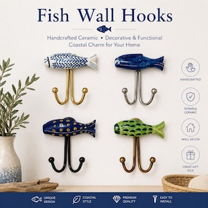 Op de afbeelding: Vier handgemaakte keramische vissen wandhaken in blauw, groen en wit. Elke haak heeft een dubbel haakontwerp. De tekst "Fish Wall Hooks" en "Coastal Charm for Your Home" wordt bovenaan de afbeelding weergegeven.