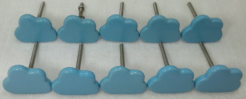 Pode incluir: Dez puxadores de arm&aacute;rio em forma de nuvem azul claro com hastes e ferragens de metal prateado. Os puxadores est&atilde;o dispostos em duas filas de cinco, mostrando um design caprichoso. Estes puxadores decorativos s&atilde;o adequados para gavetas e arm&aacute;rios.