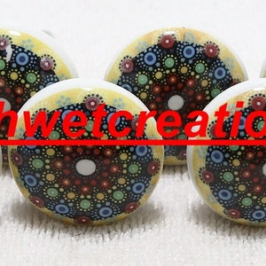 May include: Ten ceramic knobs with a yellow background and a colourful mandala design. The mandala is in shades of blue, green, red, and black.