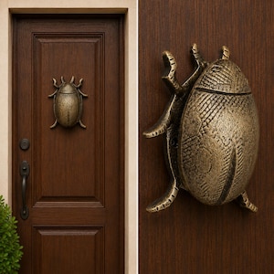 May include: A bronze-toned metal door knocker shaped like a beetle with a textured, segmented shell and six legs. The knocker is mounted on a dark brown wooden door featuring a vertical panel design, a black handle, and a matching black deadbolt lock.