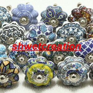 May include: Assortment of 18 ceramic drawer knobs with various floral and geometric patterns in shades of blue, red, green, yellow, and white. Each knob has a silver metal base.