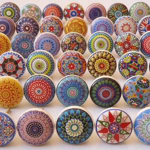 Puede incluir: Surtido de pomos de cer&aacute;mica coloridos con intrincados dise&ntilde;os de mandalas. Los pomos son redondos y tienen una base blanca con varios colores y patrones.