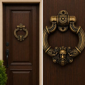 Peut inclure: Un heurtoir de porte circulaire en laiton avec une finition antique, présentant un relief détaillé d'un visage humain en bas et un motif floral sur la plaque de montage supérieure, fixé sur une porte en bois brun foncé avec poignée noire.