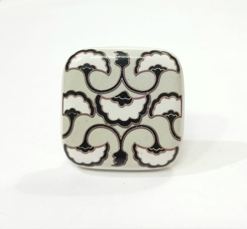 May include: Square ceramic knob with a black and white floral design on a light green background.