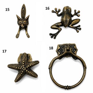 Puede incluir: Una colecci&oacute;n de cuatro piezas de herrajes de metal en tono lat&oacute;n antiguo numeradas del 15 al 18. El art&iacute;culo 15 es un tirador con forma de zorro, el 16 de rana, el 17 de estrella de mar y el 18 es un tirador de anillo con placa decorativa.