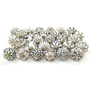 May include: A selection of decorative ceramic cabinet knobs. The knobs are white with black and brown floral and geometric designs. Each knob has a silver-toned metal base.
