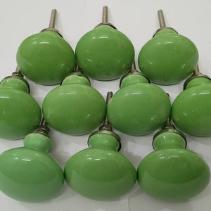 May include: Ten green ceramic cabinet knobs with silver metal stems.
