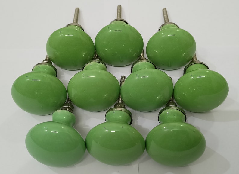 May include: Ten green ceramic cabinet knobs with silver metal stems.