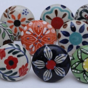 Puede incluir: Surtido de 14 pomos de caj&oacute;n de cer&aacute;mica con varios patrones florales y geom&eacute;tricos en azul, verde, rojo, naranja y blanco.