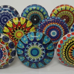 Może przedstawiać: Dziesięć kolorowych ceramicznych gałek z misternymi wzorami mandali w odcieniach niebieskiego, czerwonego, ż&oacute;łtego, zielonego i białego.