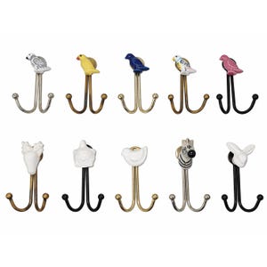 May include: A collection of decorative wall hooks with animal and bird designs. The hooks feature a variety of colors, including silver, gold, and black. The animal and bird toppers are made of ceramic.