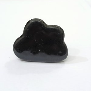 Pu&ograve; includere: Un anello nero a forma di nuvola. L'anello &egrave; fatto di un materiale liscio e lucido.