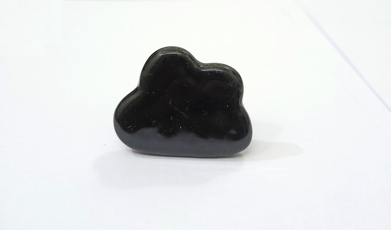 Pu&ograve; includere: Un anello nero a forma di nuvola. L'anello &egrave; fatto di un materiale liscio e lucido.