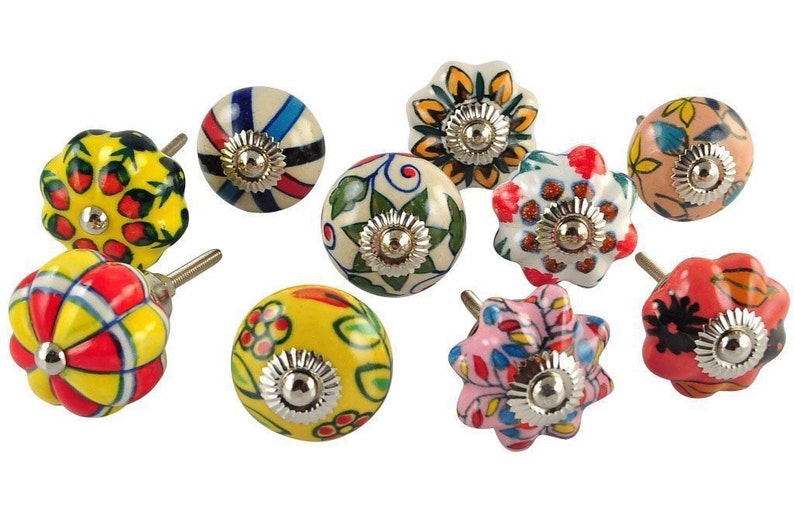 May include: Ten colorful ceramic cabinet knobs with different floral and geometric patterns. The knobs are round and have a silver metal base.