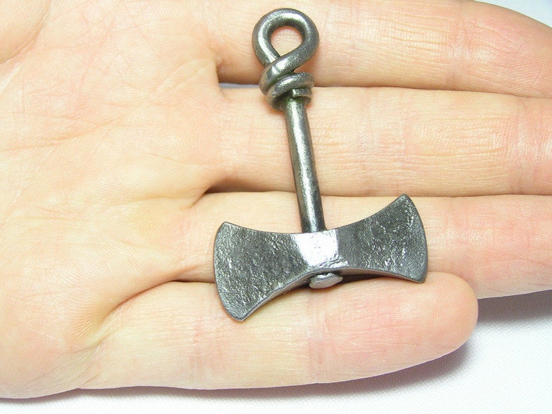 May include: A small, silver-colored, double-headed axe pendant with a twisted loop at the top.
