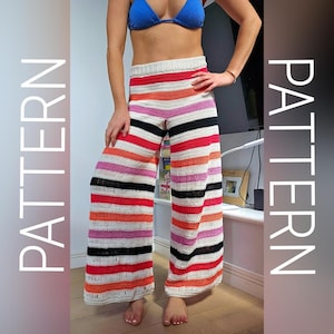 Op de afbeelding: Gehaakte broek met wijde pijpen en horizontale strepen in rood, oranje, roze, zwart en wit. De broek heeft een hoge taille en een relaxte pasvorm. Het woord "PATTERN" staat verticaal aan de linkerkant van de afbeelding.