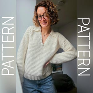 Puede incluir: Suéter crema de manga larga con cuello. El suéter tiene una textura acanalada y un ajuste relajado. La palabra "PATTERN" se muestra verticalmente en el lado izquierdo de la imagen. La persona lleva vaqueros azules.
