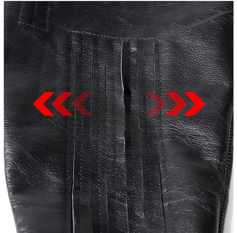 A close-up view of a black leather item with a distinctive texture, featuring a series of red arrows pointing in opposite directions.