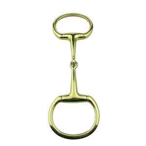 May include: A gold-coloured horse bit, featuring a ring at each end and a central bar. This bit is designed to be placed in a horse's mouth and connected to the reins for control. The metal has a polished finish.